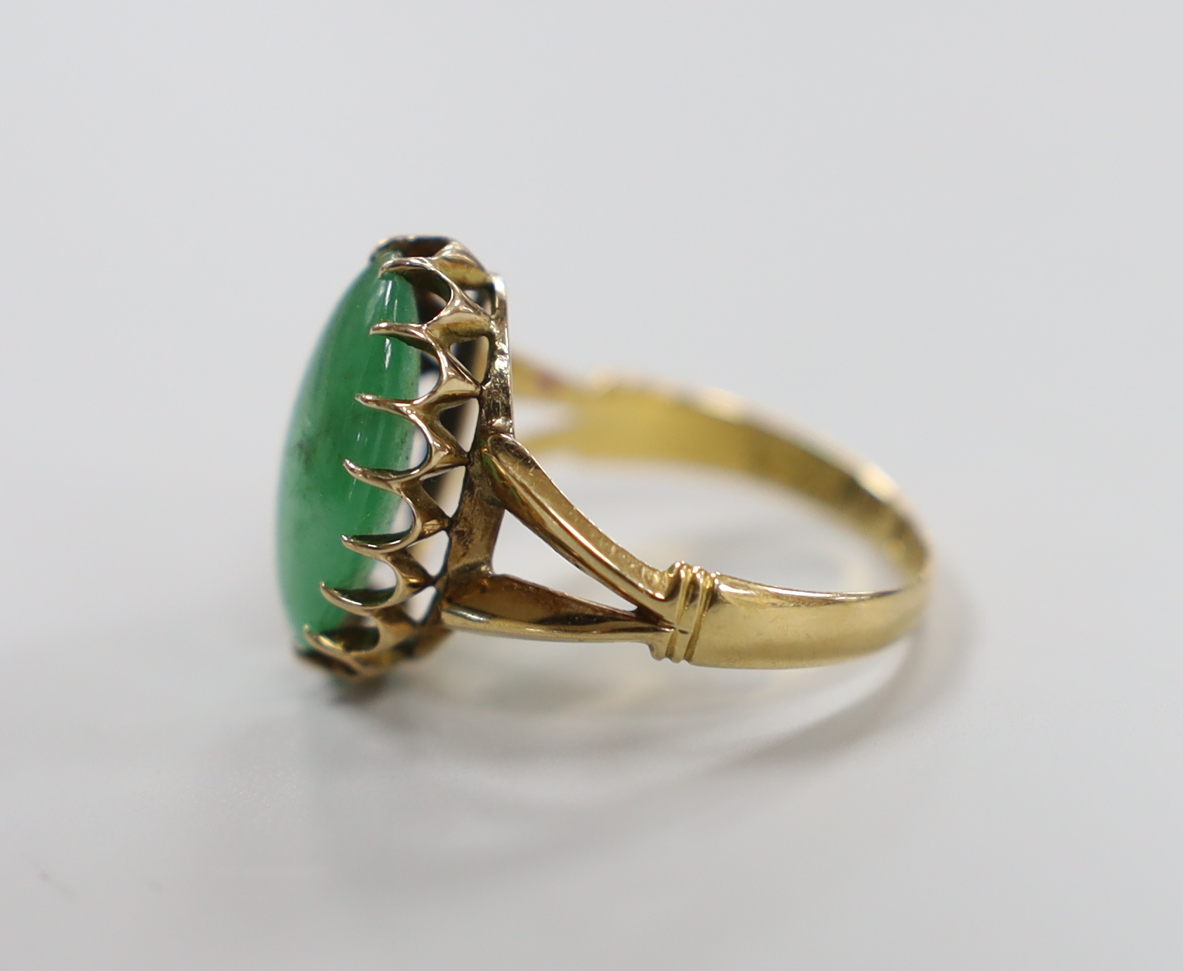A Chinese yellow metal and cabochon jade set oval ring, size Q/R, gross weight 5 grams.